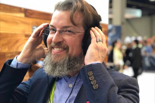EIC wearing headphones smiling.