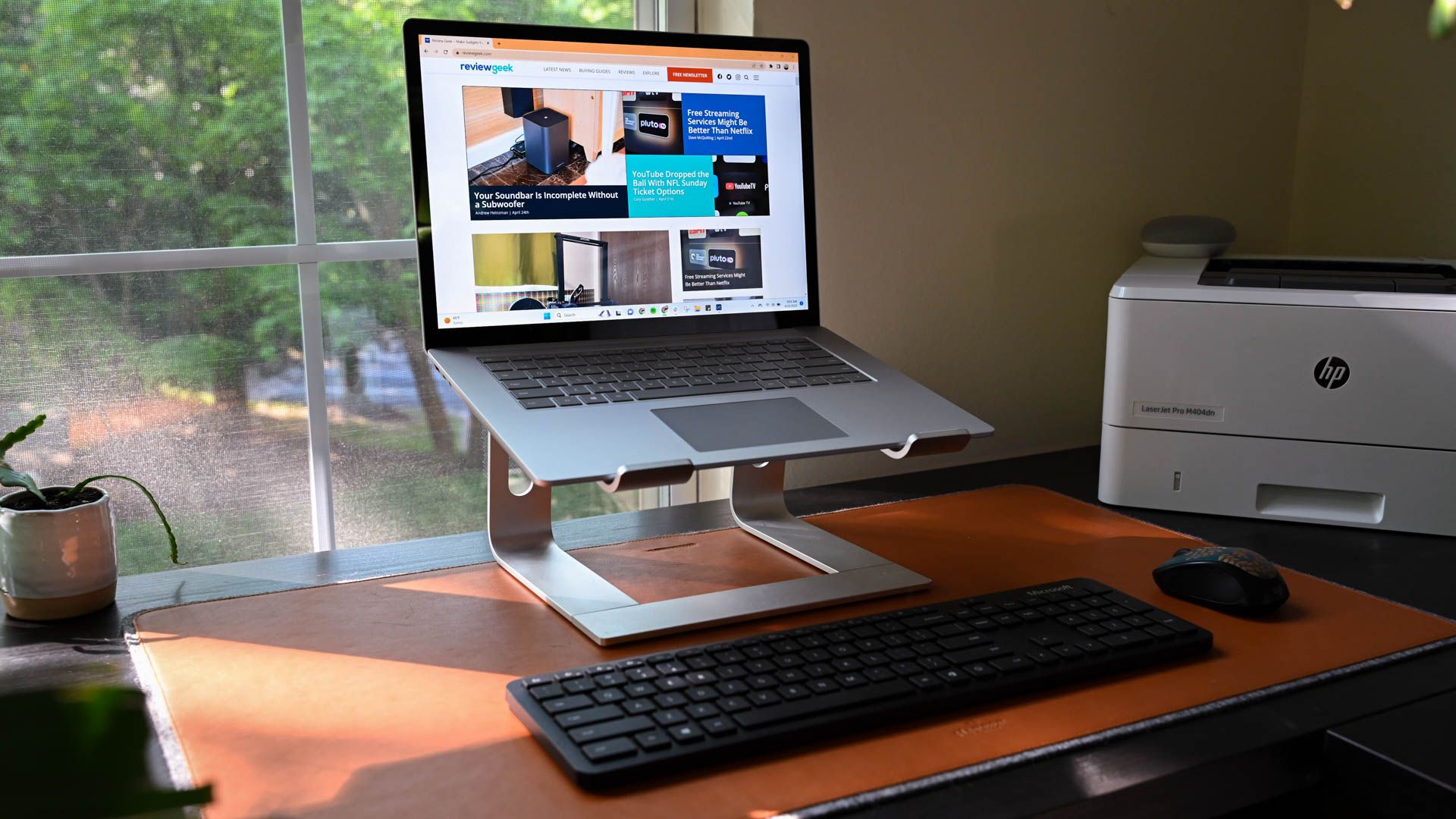 A work from home setup with a Microsoft Surface Laptop set up on a laptop stand with a mouse and keyboard.
