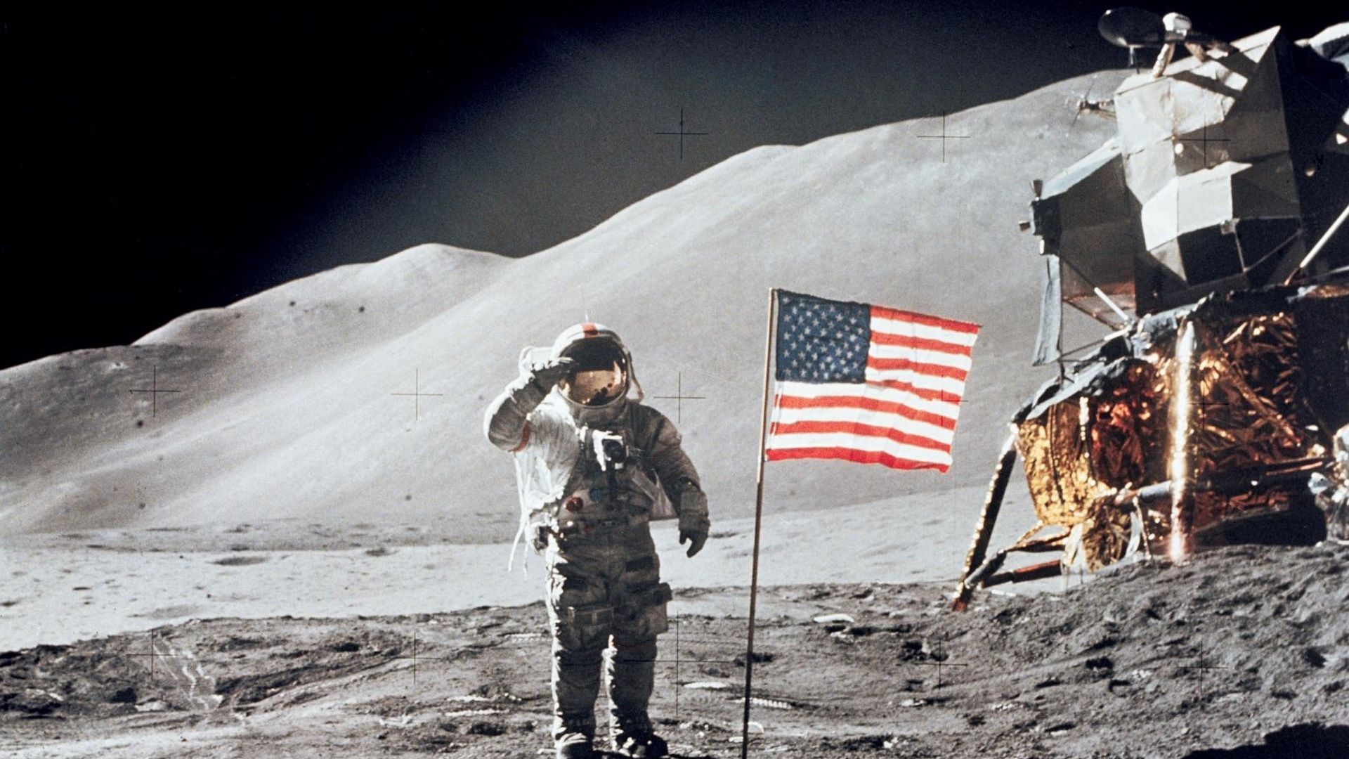Astronaut on the moon saluting next to an American flag.