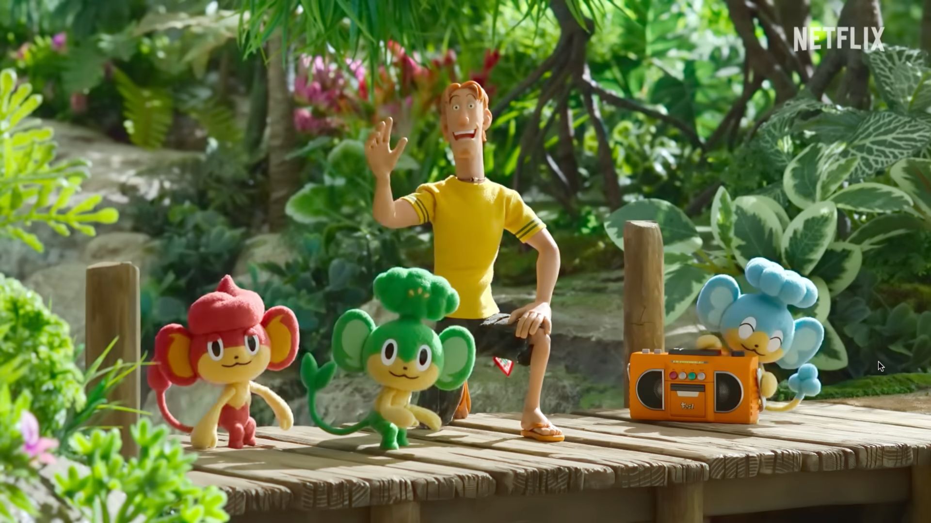 Pokémon Concierge still from Netflix animation showing three monkey pokémon and a man in a yellow T-shirt.