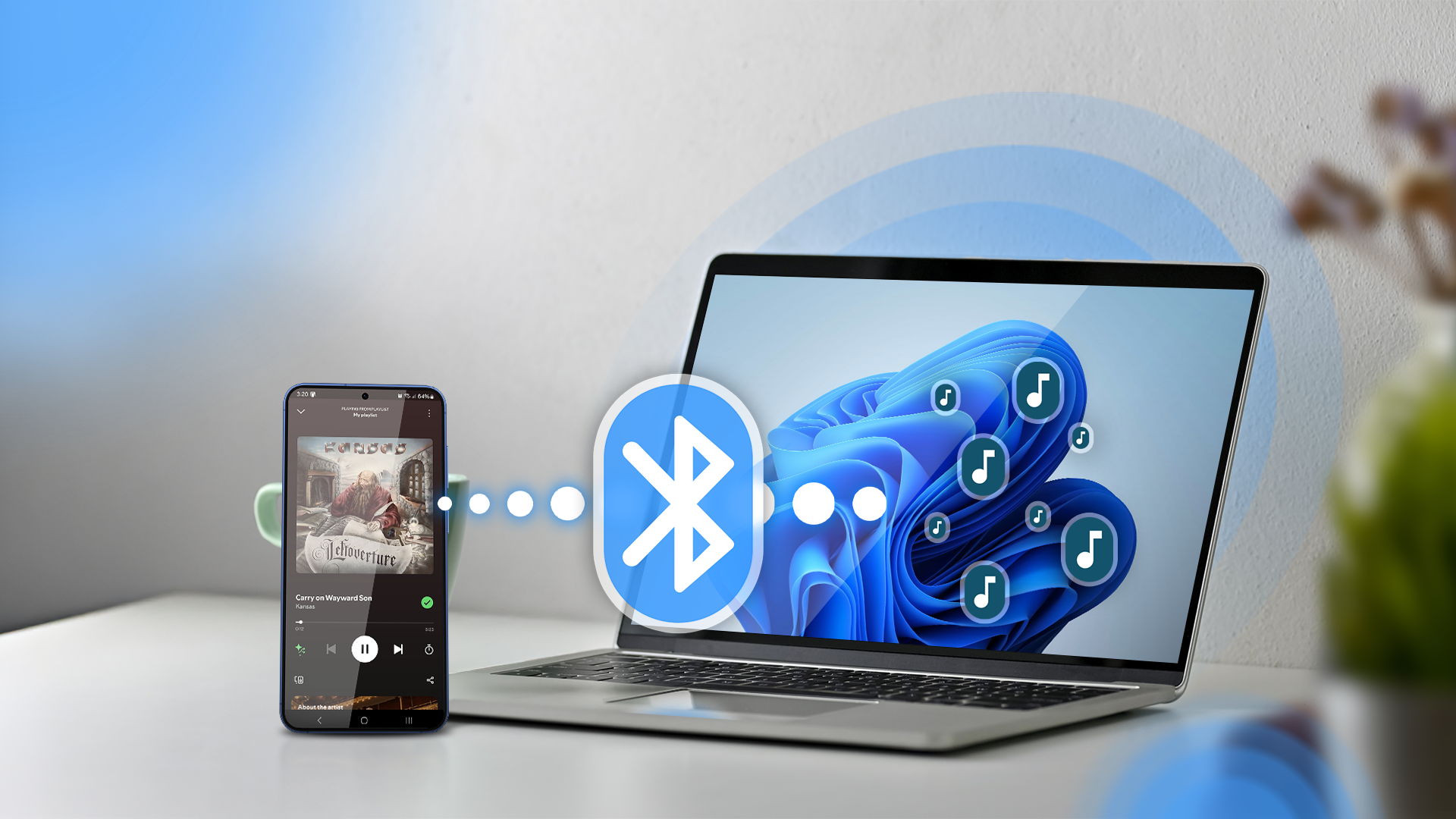 A phone playing music and a Windows 11 laptop next to it with a Bluetooth icon between them.