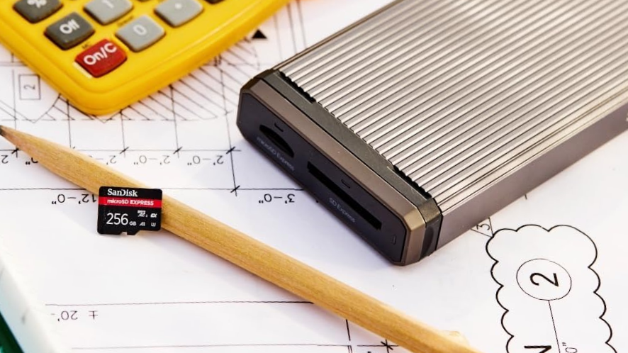 SanDisk Micro SD Express on pencil near external drive and calculator-1