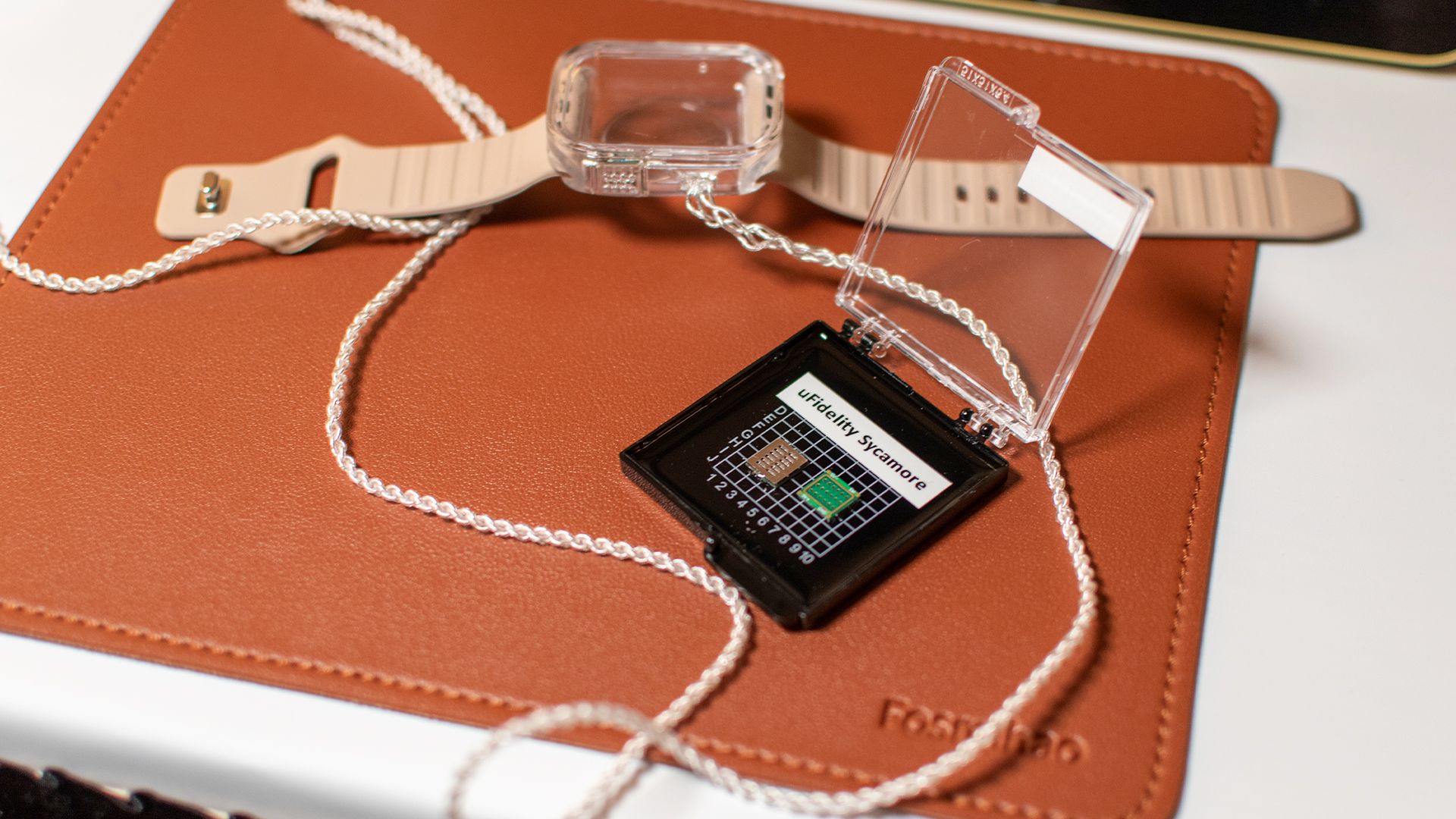 The original xMEMS Sycamore driver next to an Apple Watch case.