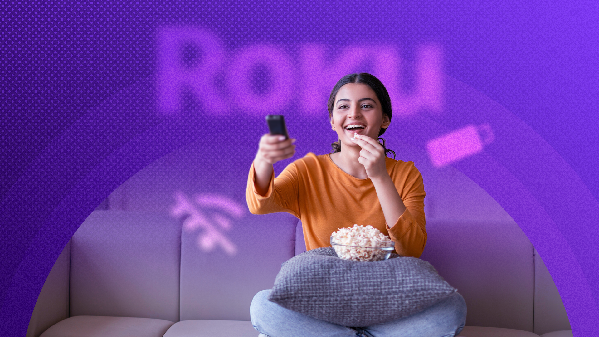 A happy woman watching TV with the Roku logo blurred in the background.