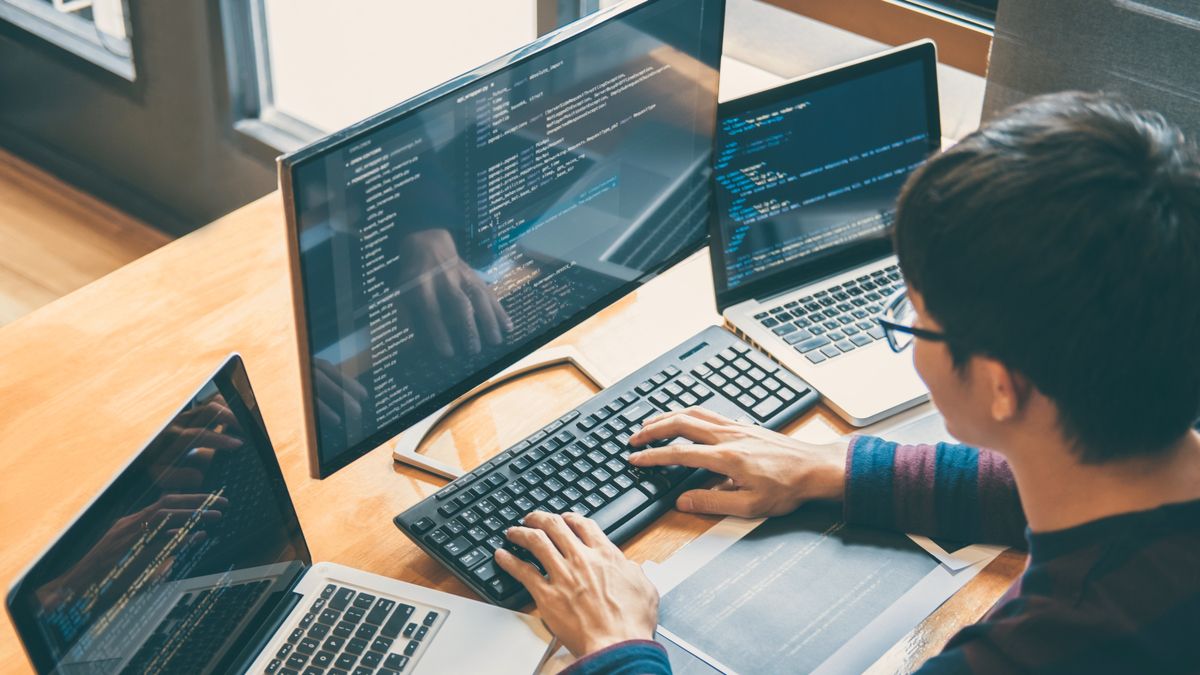 Person coding on multiple devices